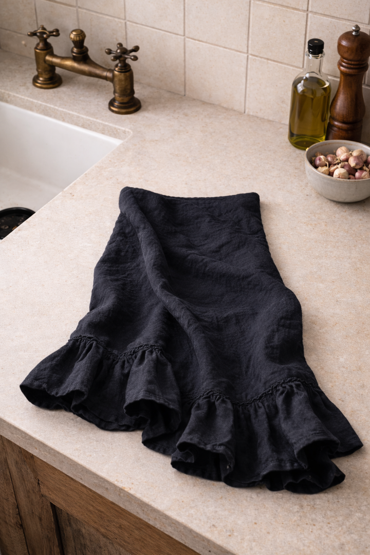 Saltbush Living black-charcoal coloured french linen Lisiére tea towel lying on kitchen bench next to the sink
